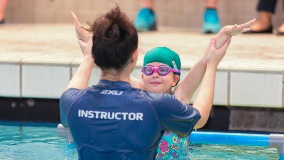 Perfect Gym Swim School lesson plan instructor helping a student